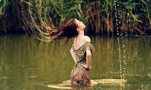 woman wearing brown and gray paisley dress on body of water thumbnail