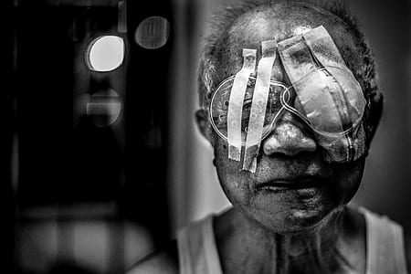 selective gray scale photography of man wearing eye bandages thumbnail