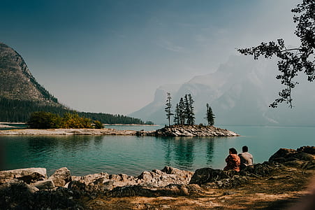 man and woman sitting on shore during daytime thumbnail