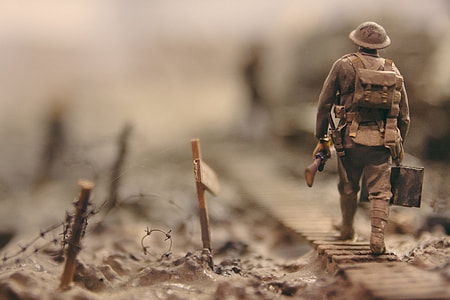 shallow focus photography of soldier carrying rifle and ammunication crate thumbnail