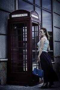 woman standing in front of telephone booth thumbnail