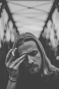 grayscale photo of man holding cigarette stick thumbnail