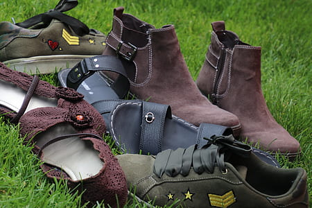 four pairs of shoes and sandals on green grass thumbnail