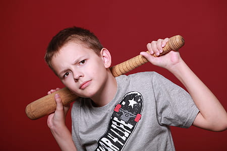 boy holding baseball bat against red background thumbnail