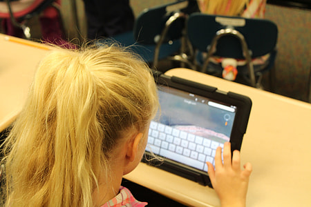 blonde haired girl using black tablet computer thumbnail