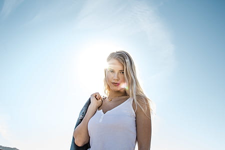 woman wearing white tank top holding gray jacket thumbnail