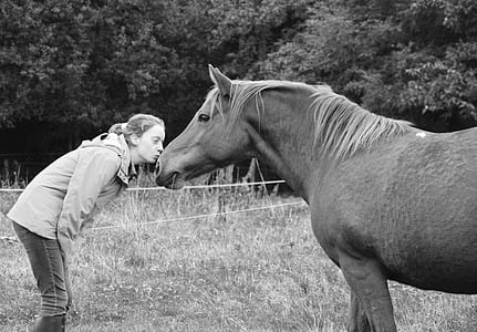 grayscale photo of woman kissing horse thumbnail