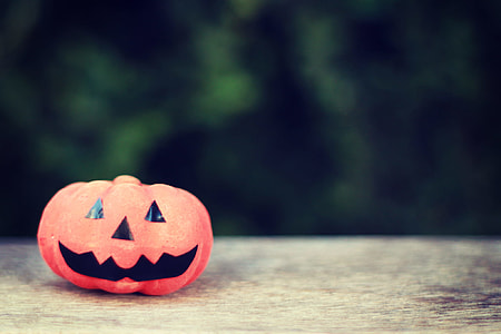 jack o lantern on brown wooden surface photography thumbnail