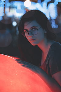 selective focus photo of woman leaning on red LED lamp thumbnail