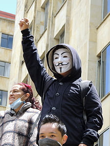 person wearing blue button-up hooded jacket and guy fawkes mask thumbnail
