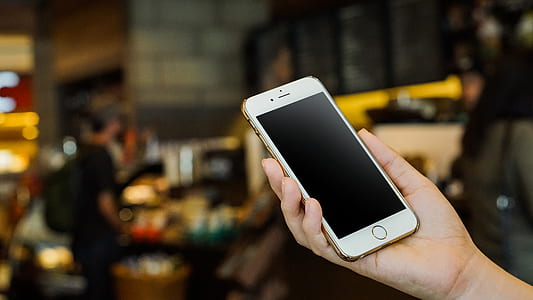 person holding turned off gold iPhone 6 thumbnail