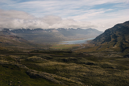 person taking photo of green grass mountains thumbnail