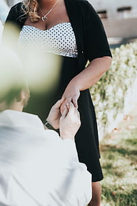 man putting ring on woman's finger thumbnail