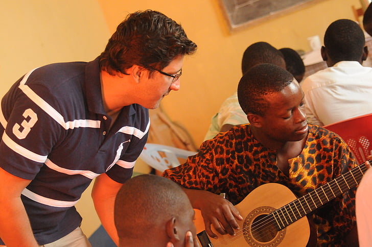man wearing leopard print shirt playing guitar