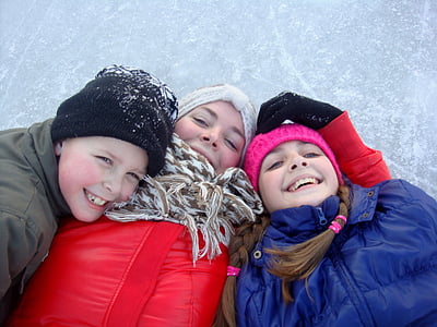 three children lying on snow thumbnail