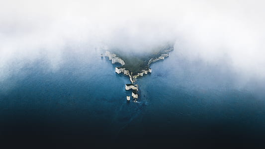 aerial photography of island covered with clouds thumbnail