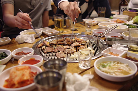 people taking meats with chopstick on brown table thumbnail