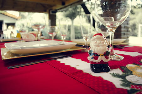 Santa Claus Ceramic Figurine Next to Wine Glasses and White Ceramic Plate thumbnail
