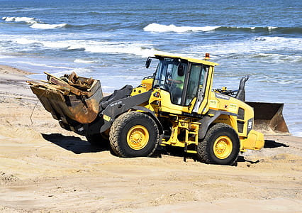 yellow backhoe beside seashore thumbnail