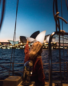 woman pointing the Sydney Opera House during night time thumbnail