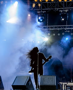 person performing on stage at night time thumbnail