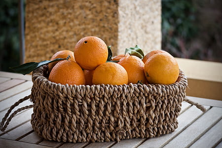 basket of orange fruit on top of brown wooden table thumbnail