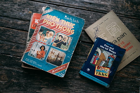 four assorted books on wooden table thumbnail