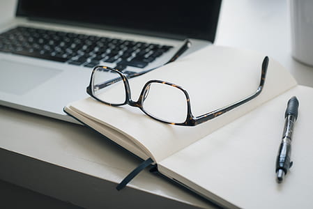 eyeglasses beside black pen on white book page thumbnail