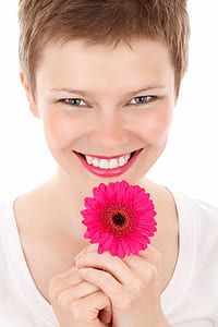 woman holding pink Gerbera daisy flower thumbnail