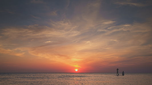 silhouette of person in body of water during golden hour thumbnail