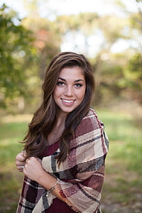 selective focus photography of woman wearing brown and black plaid scarf thumbnail