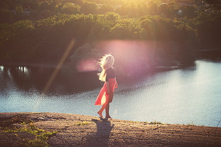 woman standing beside body of water at daytime thumbnail