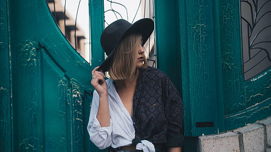woman wearing black and white deep V-neck shirt holding black sun hat thumbnail