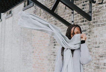 girl wearing gray scarf in front of brick wall thumbnail