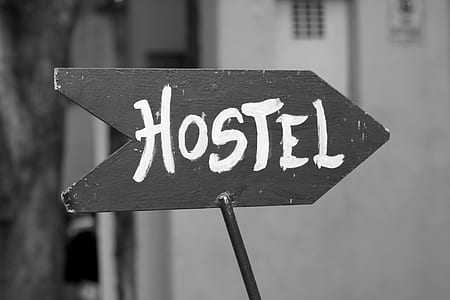 grayscale photography of wooden hostel road signage thumbnail