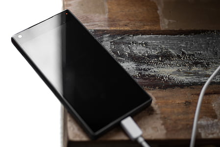 black smartphone on brown wooden surface thumbnail