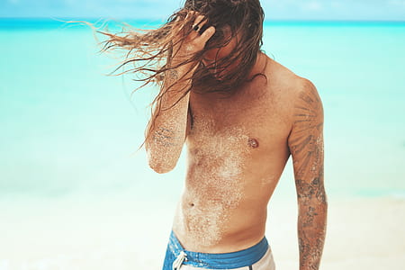 topless man standing in beach thumbnail