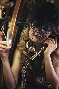 woman in black fascinator hat holding gold crank phone thumbnail