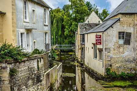 river between houses under blue sky thumbnail