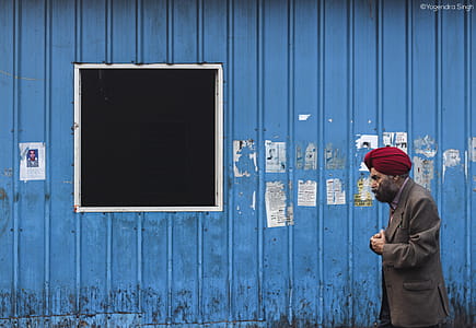 Man Walking Beside Blue Wall thumbnail