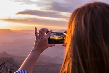 woman taking photo of sunset thumbnail