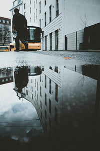 worm's eye view photography of man walking on the stret thumbnail