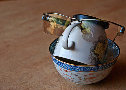 close photo of sunglasses on white ceramic tea cup thumbnail