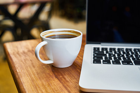 coffee mug beside MacBook thumbnail