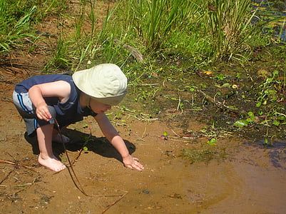 boy holding mud near grass thumbnail