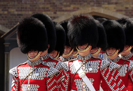 men wearing red uniforms and black hats thumbnail