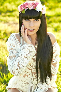 woman wearing white floral long-sleeved top and pink floral headdress thumbnail