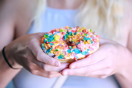 Person Holding Doughnut With Toppings thumbnail