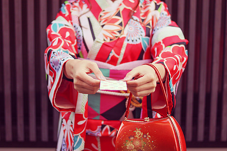 woman holding paper wearing floral kimono and handbag thumbnail