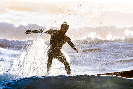 man riding surfboard on body of water thumbnail